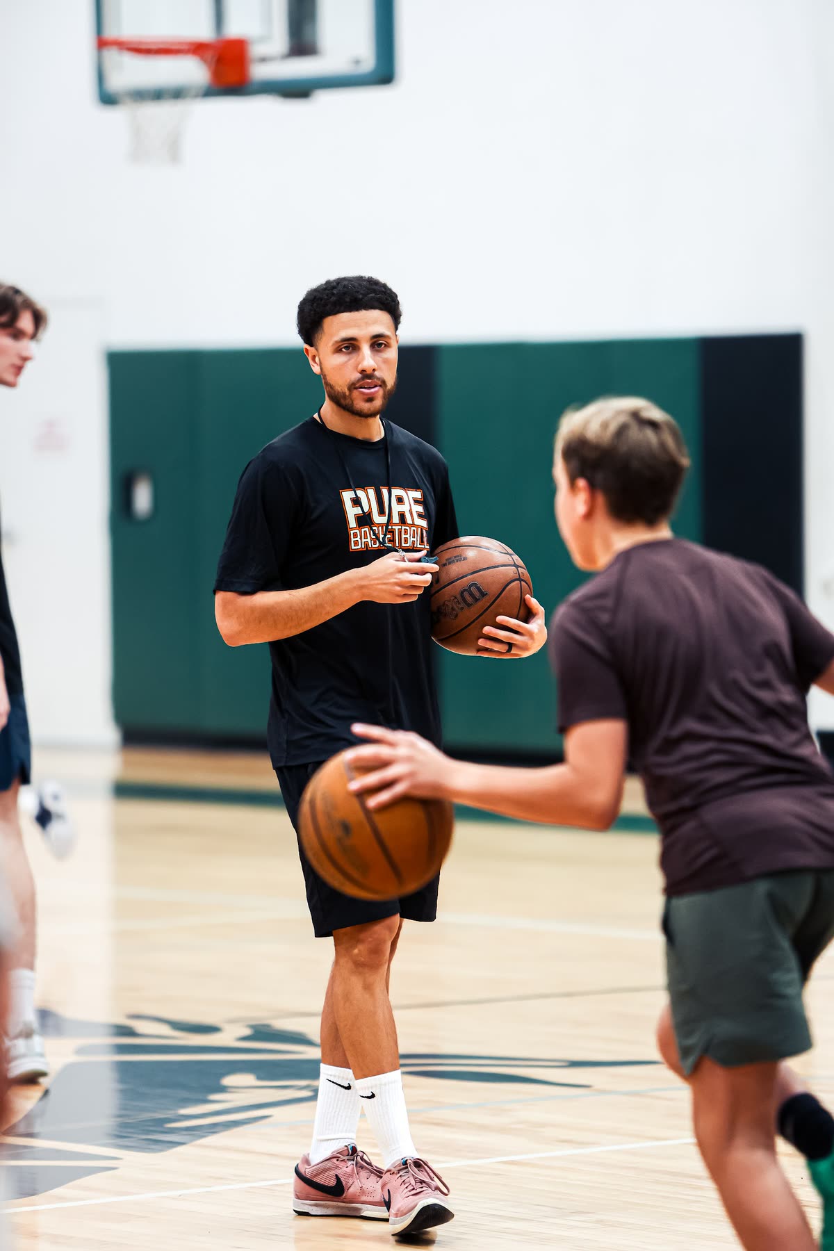 Coach Isaiah, ball in hand, working with a young player