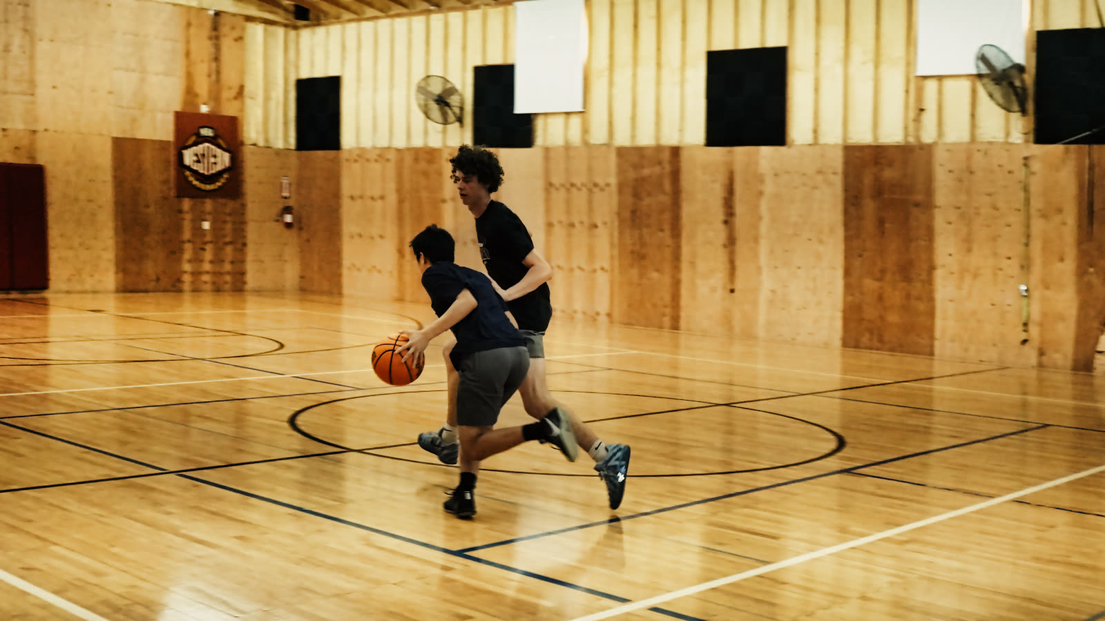 Two players going one on one, the ball handler driving past their defender
